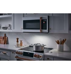 a stove top oven sitting inside of a kitchen next to a microwave above a counter