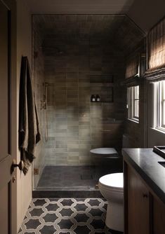 a bathroom with a toilet, sink and shower