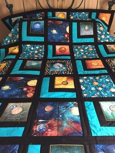 a bed with a quilt made to look like the outer planets