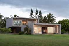 a modern house is shown in the middle of a grassy area with trees and bushes