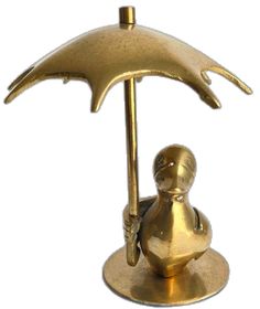 a gold figurine holding an umbrella on top of a metal stand with a white background