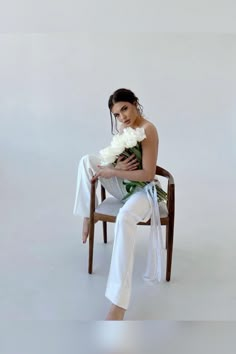 a woman sitting in a chair holding a bouquet of flowers