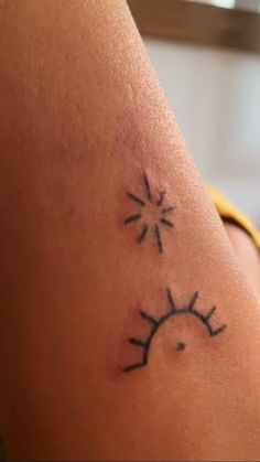 a woman's arm with a sun and stars tattoo on her left side shoulder