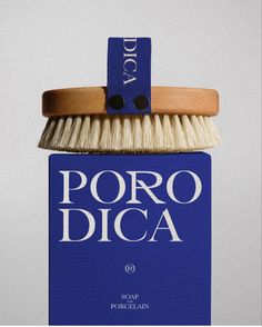 a blue box with a white bristles on it and the words poro dica above it