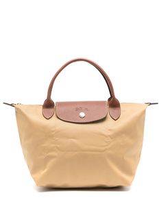 Find LONGCHAMP Le Pliage Original Tote Bag on Editorialist. The Longchamp Le Pliage Original Tote Bag features a coated finish, leather trim, embossed logo to the front, and debossed logo to the rear. It has a branded zip puller, foldover top with press-stud fastening, top zip fastening, two flat top handles, a main compartment, multiple internal slip pockets, and gold-tone hardware. It also comes complete with a protective dust bag. This small tote bag is perfect for everyday use and can be hand carried or worn on the shoulder. It features a logo, top handle, and gold-tone hardware. Mustard Yellow Coat, Longchamp Small Le Pliage, Longchamp Bags, Debossed Logo, Zip Puller, Small Tote Bag, Woman Bags Handbags, Iconic Bags, Summer Beach Wear