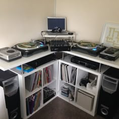 a room with two turntables and several other electronic equipment on the shelves in front of it