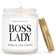 a candle that says boss lady smells like chaos in front of a white background and gold lid