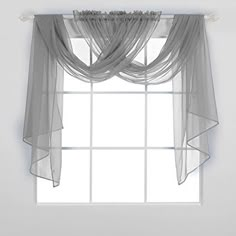 a white window with sheer curtains hanging from it's side