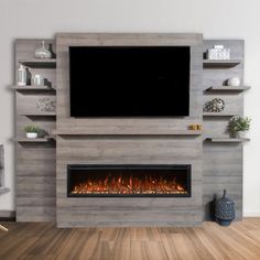 a tv mounted on the wall above a fire place in a living room with wood flooring