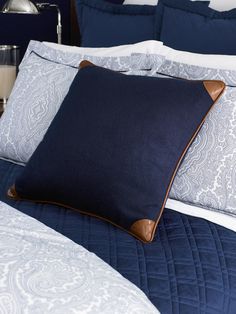 a bed with blue and white comforters and pillows