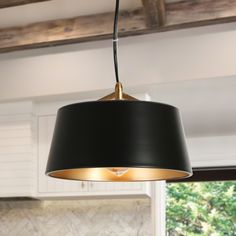 a black lamp hanging from the ceiling in a kitchen