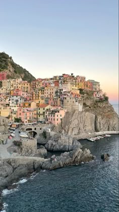 a small village on the side of a cliff next to the ocean