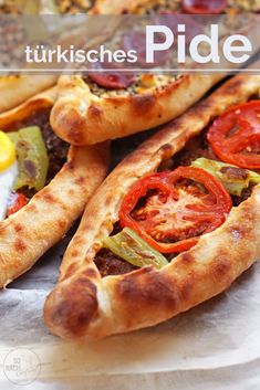 three pizzas with different toppings sitting on top of a paper towel next to each other