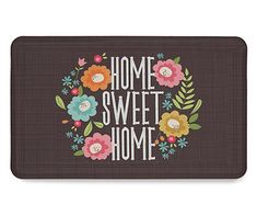 a door mat that says home sweet home with flowers and leaves around the words on it