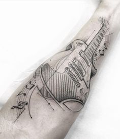 a man's arm with a guitar tattoo on the left side of his arm