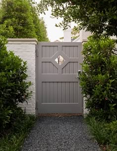 an entrance to a white house surrounded by greenery