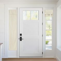 a white front door with two windows and a towel hanging on the wall behind it