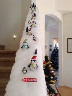 a christmas tree made out of snow with penguins on it