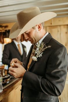 a man in a cowboy hat standing next to another man wearing a suit and tie