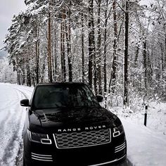 a range rover is parked on the side of a snowy road in front of trees