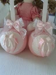 two pink baby booties sitting on top of a table next to a teddy bear