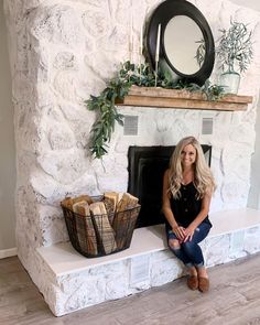 a woman sitting on a bench in front of a fireplace