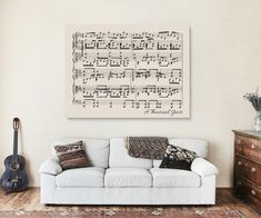 a living room with a white couch and musical notes hanging on the wall above it