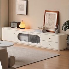 a living room with a white entertainment center and an area rug in front of it