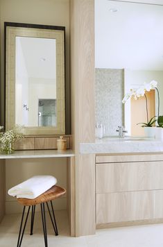 a bathroom with a vanity, mirror and stool