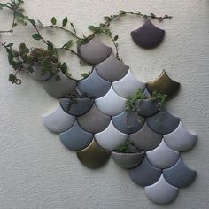 some plants are growing out of pots on the wall