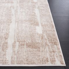 an area rug with brown and white colors on the floor in front of a black chair