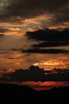 the sun is setting behind some clouds in the sky