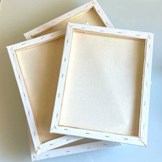 two empty white frames sitting on top of a table