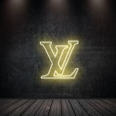 an illuminated louis vuitton sign on a wall in a dark room with wooden floors