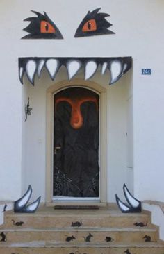 the front door is decorated with black and orange monster heads on it's face