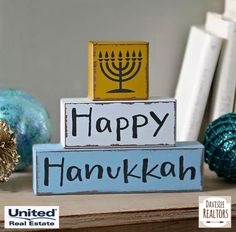 a happy hanukkah sign sitting on top of a wooden block