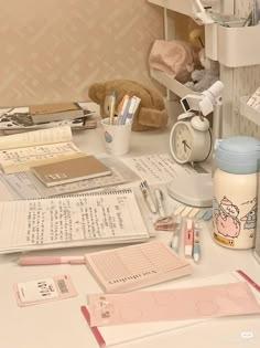 the desk is cluttered with books, pens and other things to write on it