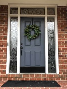 a gray front door with a wreath on it