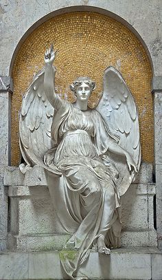 a statue of an angel sitting on top of a stone bench next to a wall