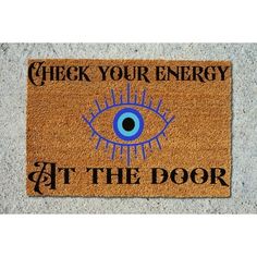 a door mat with the words check your energy at the door and an eye on it