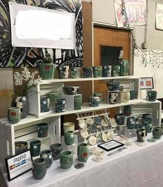 there are many cups and bowls on display at this table with a sign that says mementoallie ceramics