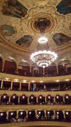 an ornately decorated auditorium with chandeliers and painted ceilinging is seen from the stage