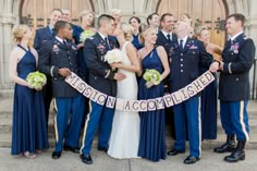 a group of people that are standing in front of a building with a ribbon around them