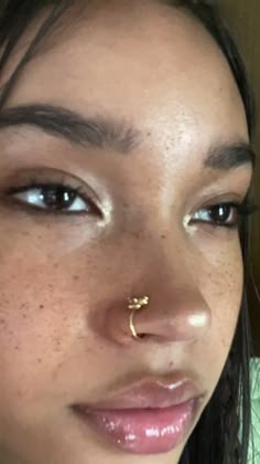 a close up of a person with a nose ring on their nose and piercing in the middle of her nose