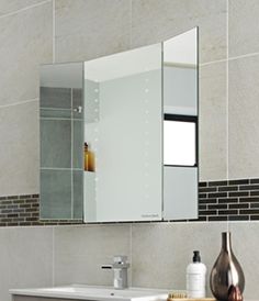 a bathroom with a sink, mirror and tiled walls