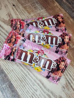 three m & m's candy bars sitting on top of a wooden table