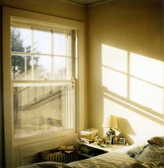 the sun shines through two windows in a bedroom