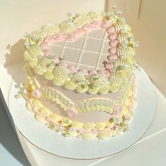 a heart shaped cake sitting on top of a white table next to a cardboard box