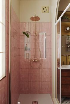 a bathroom with pink tiles and a shower head in the corner next to a sink