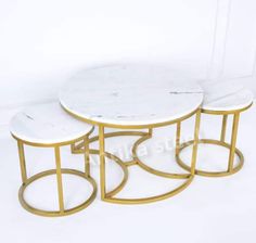 three white marble tables with gold metal bases